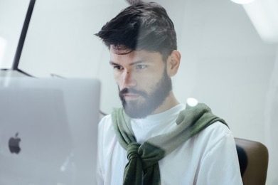 man looking at Apple computer