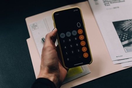: hand holding iPhone calculator